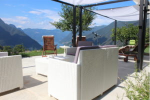 [:it]Patio esterno fronte lago con pergola e sdraio per clienti[:en] Outdoor patio facing the lake with pergola and deck chairs for guests[:]